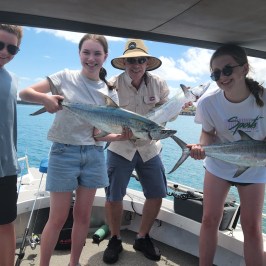 a woman holding a fish on a boat
