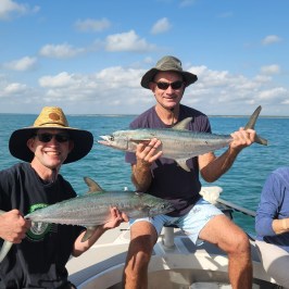 a person holding a fish on a boat in a body of water