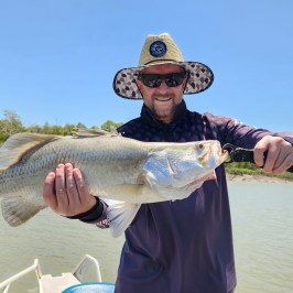 a man holding a fish in the water