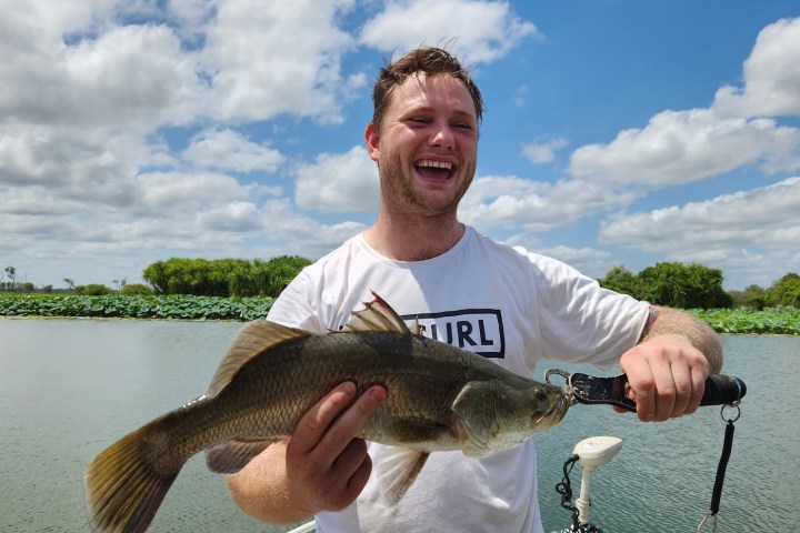 a man holding a fish in the water
