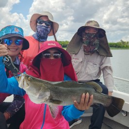 a person holding a fish on a boat