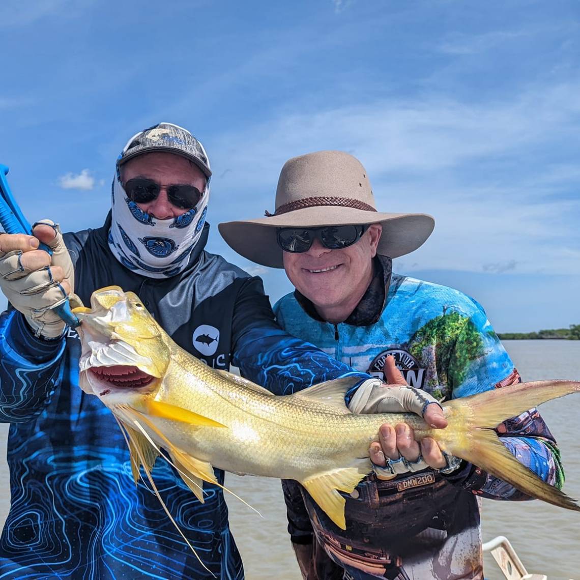 a person holding a fish on a boat in a body of water
