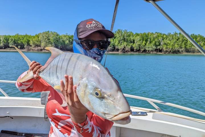 a person holding a fish on a boat in a body of water