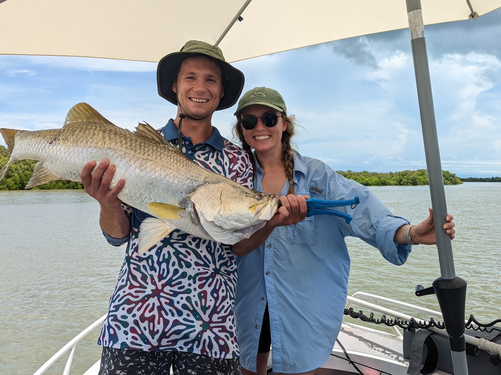 a person holding a fish on a boat in a body of water
