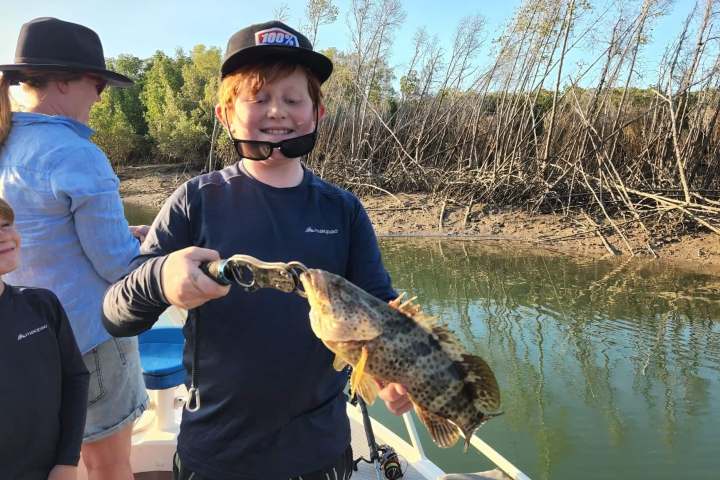 a man holding a fish in the water