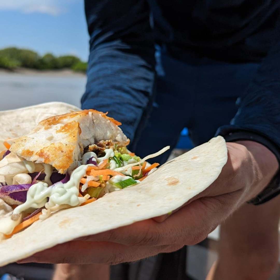 a person holding a slice of pizza
