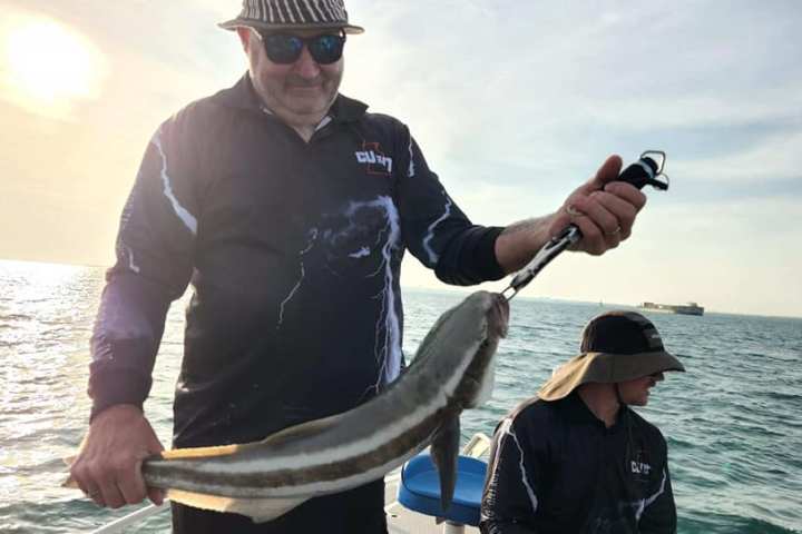 a man holding a fish in the water