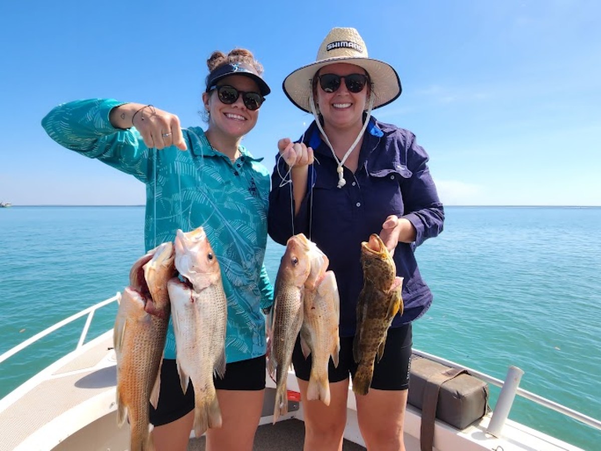 a person holding a fish on a boat in a body of water