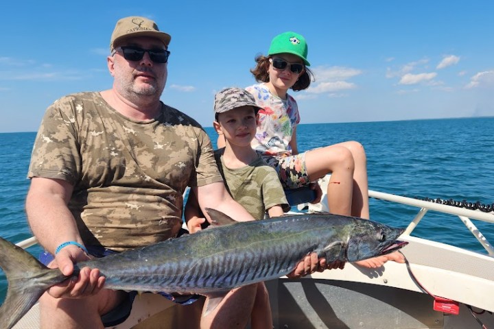 a man holding a fish in the water