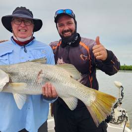 a person holding a fish in the water