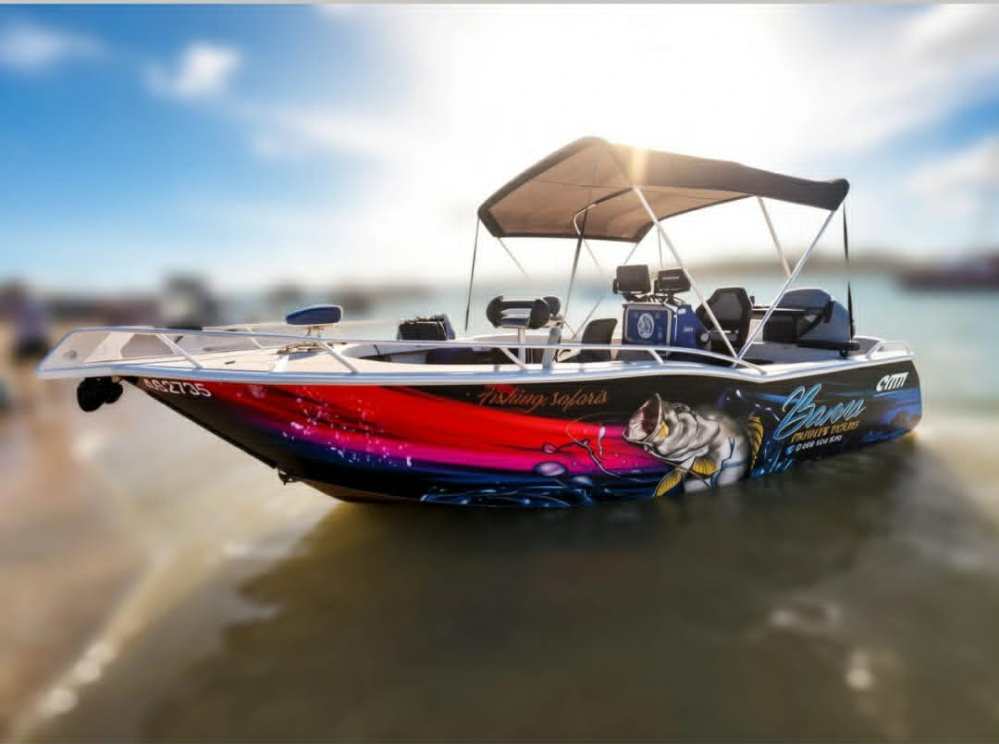 White boat with canopy and fish graphic docked near shore.