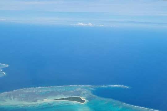 View from airplane window of islands and blue ocean.